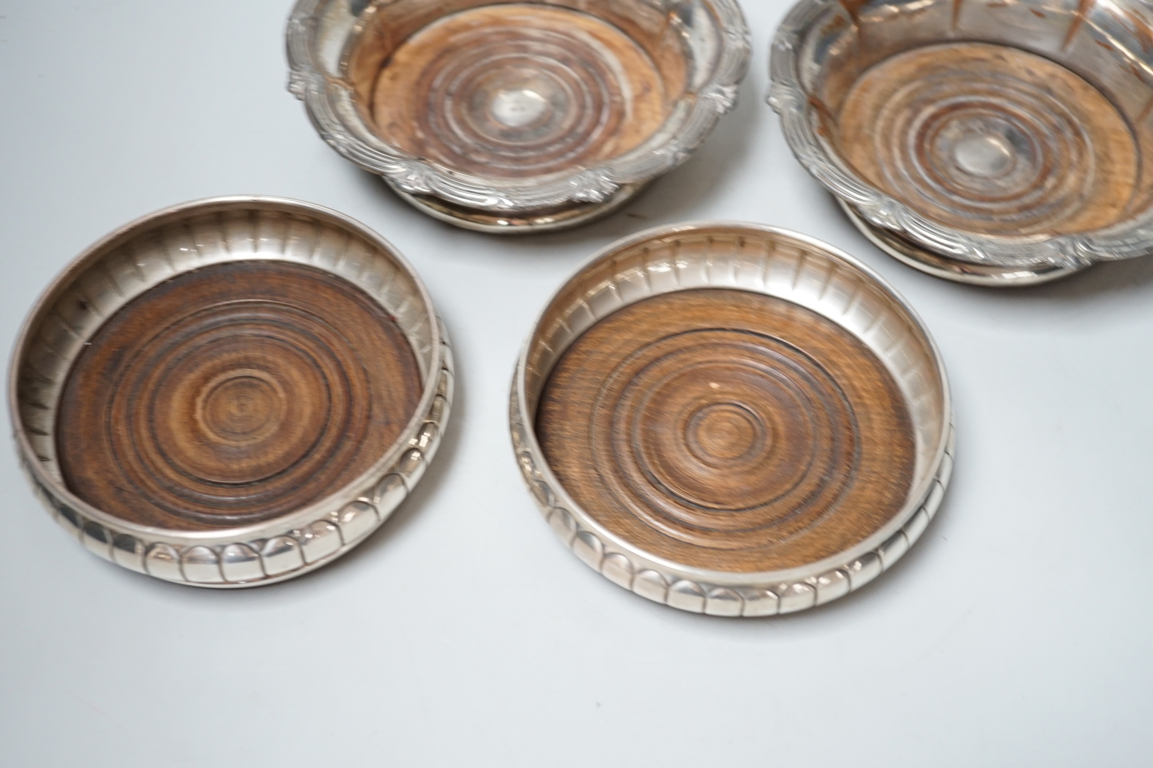 A pair of Elizabeth II silver wine coasters, London, 1973, diameter 13.4cm and a plated pair of wine coasters.